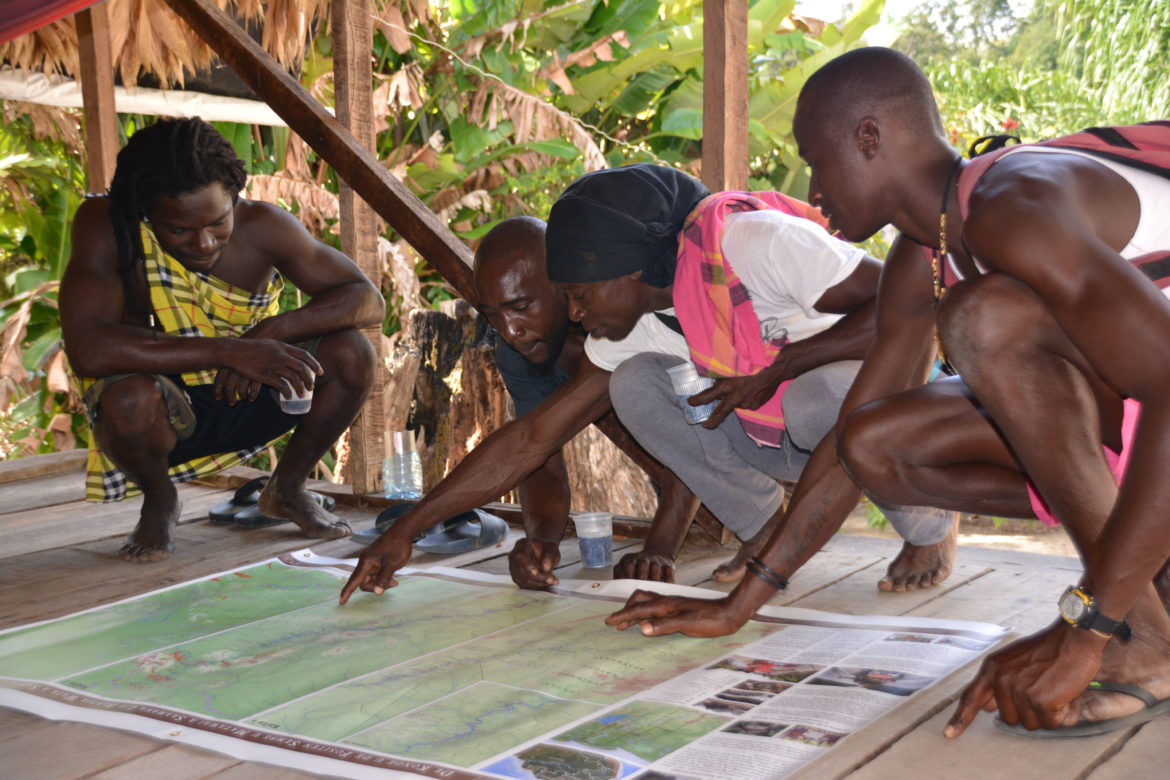 Matawai boatsmen examining a map of their ancestral lands. Credit: Mirjam Gommers